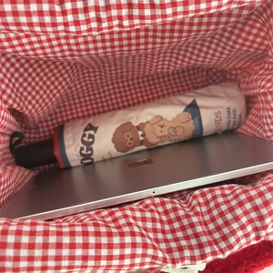Innenansicht der Plüsch-Tragetasche mit rot-weißem Karofutter für Laptop und Schirm