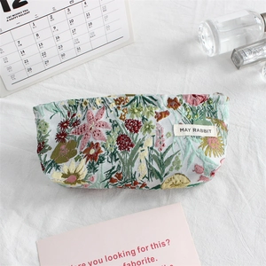 Detail of floral embroidery on canvas makeup bag with premium metal zipper closure