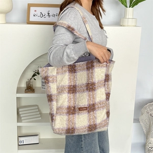 Detail of checkered plush tote bag in purple and white with soft fleece texture