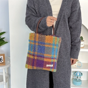 Close-up of colorful plush tote bag featuring soft fleece texture and woven logo tag