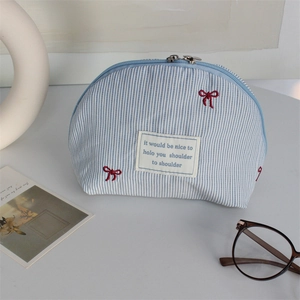 Blue striped shell-shaped toiletry bag with red bow embroidery and dual zippers