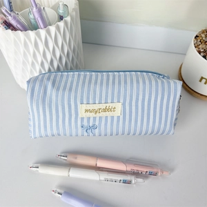 Detailed view of a light blue and white striped pencil case featuring a logo patch