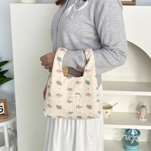 Close-up of elephant print bubble textured tote bag with yellow checkered lining detail