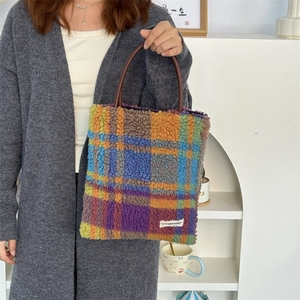 Close-up of colorful checkerboard plush tote bag with a soft fleece texture and logo tag