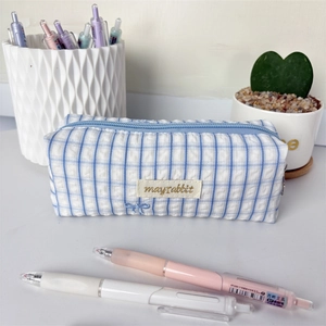 Close-up of blue striped pencil case with exquisite butterfly embroidery and fabric label