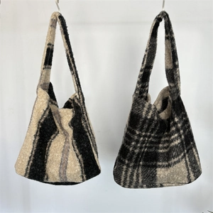 Detail of plush tote bags showing black stripes and plaid textures on soft faux fur fabric