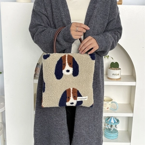 Detail of plush fleece tote bag featuring cartoon dog embroidery and brown round handles