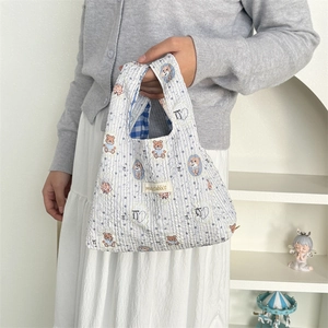 Detail of quilted cotton tote bag with cartoon bear pattern and blue checkered design