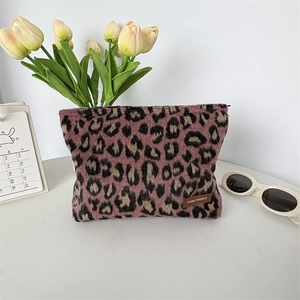 Gros plan sur la trousse de maquillage léopard en peluche avec fermeture éclair et cuir