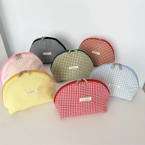 Top view of seven colorful plaid shell cosmetic bags with double metal zippers