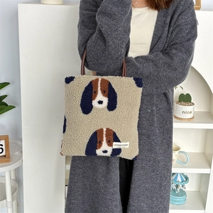 Close-up of plush faux fur tote bag with cartoon dog pattern and leather handles