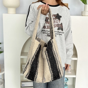 Detail of black and white striped plush tote bag with soft faux fur texture and handle