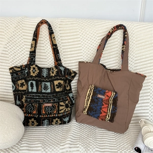 Detail of plush tote bags with floral patterns and side pockets on a white sofa