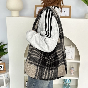 Detail of plush checkered tote bag featuring black, grey and beige patchwork texture