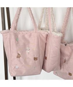 Detail of pink plush tote bag with winter snowman and teddy bear embroidery