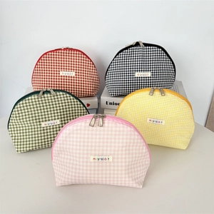 Close-up of gingham shell makeup bags with double zippers in various colors