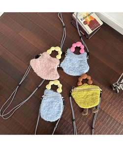Detail of colorful fluffy mini crossbody bags with wavy handles on wooden floor