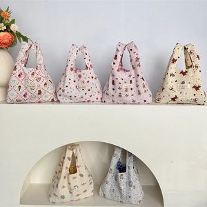 Close-up of quilted bubble floral handbags in diverse patterns on minimalist display stands