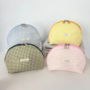 Set of four pastel plaid shell makeup bags in blue, yellow, green, and pink colors