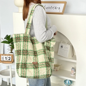 Detail of checkered plush tote bag showing the soft wool texture and leather logo tag