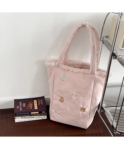 Detailed close-up of pink plush tote bag featuring winter teddy bear and snowman embroidery