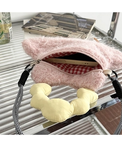 Internal detail of pink plush phone bag showing red checkered lining and zip closure