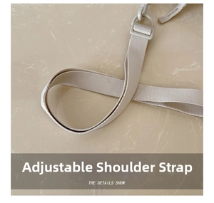Detail of adjustable beige fabric shoulder strap with matching plastic buckle and hook