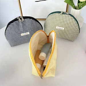 Three-piece checkered shell makeup bag set in black, green, and yellow patterns