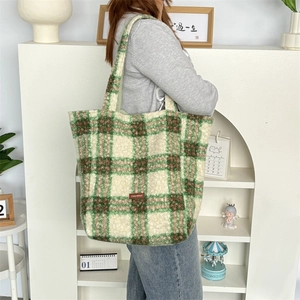 Close-up of green and white checkered plush tote bag with branded leather patch