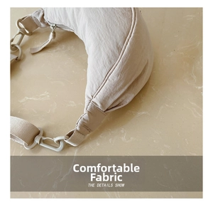 Detail of beige crescent crossbody bag with wrinkled fabric texture and plastic buckle