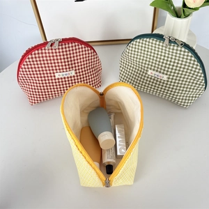 Detailed interior of checkered shell makeup bag showing storage capacity and zipper