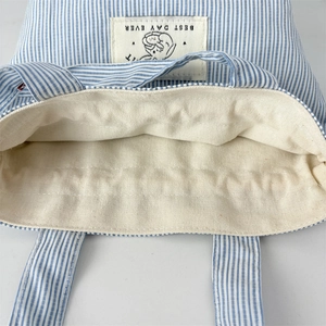 Détail macro du sac en toile à rayures bleues avec étiquette blanche et doublure robuste