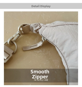 Detail of smooth beige nylon fabric with matching color plastic zipper and buckle fasteners