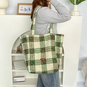 Detail shot of the plush plaid tote bag featuring soft beige, green, and brown textures