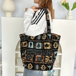 Detail of plush tote bag showing colorful geometric nature patterns and brand label