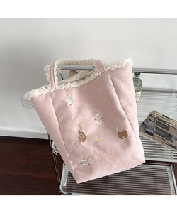 Detail of pink plush tote bag with festive Christmas embroidery and soft faux fur trim