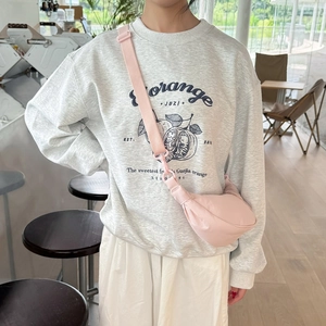 Detail view of water-resistant light pink dumpling crossbody bag with adjustable strap