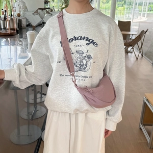 Pink nylon crossbody crescent bag shown on model for a trendy and casual everyday look