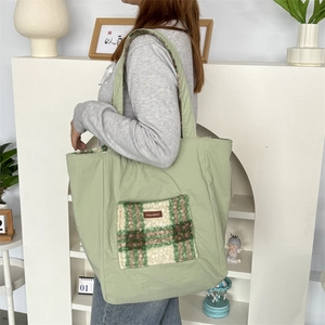 Detail of mint green tote bag with checkerboard plush pocket and brand label