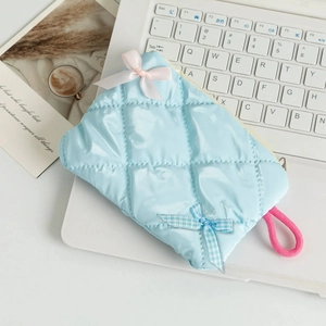 Close-up of a light blue quilted pouch with cute pink and blue ribbon bow details