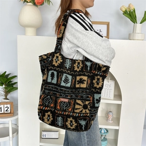 Detail view of large plush tote bag with brown Nordic geometric pattern and brand label