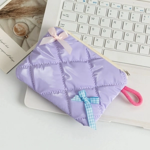 Detail of lavender quilted coin purse with satin bows on a laptop keyboard background
