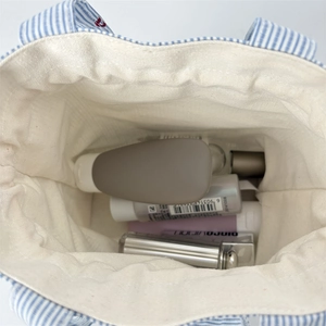Vue intérieure du sac en toile à rayures bleues montrant l'espace pour cosmétiques