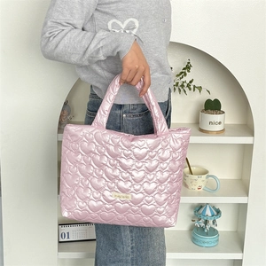 Pink heart quilted tote bag with metallic sheen finish shown in a lifestyle home setting