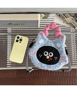 Detailed close-up of a blue plush cat-shaped crossbody bag with a black-white braided strap