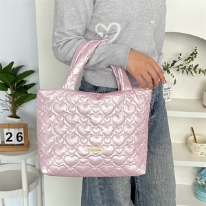 Close-up of pink heart-quilted puffer handbag with glossy finish and logo label