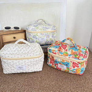 Trousse à maquillage en coton matelassé avec motifs floraux et poignée supérieure