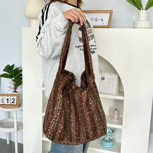 Close-up of brown fuzzy tote bag with green stripes and textured knit fabric detail