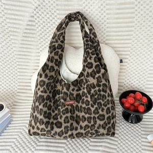 Detailopname van luipaardprint pluche draagtas met leren label en zachte voering