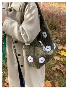 Detail of green plush tote bag with white flower embroidery and wood toggle closure